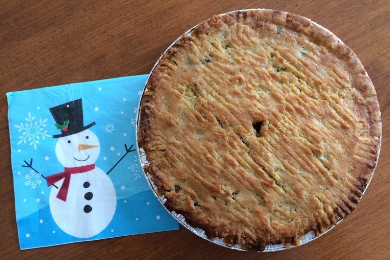 A Gluten-Free Meat Pie with a snow man napkin next to it. 